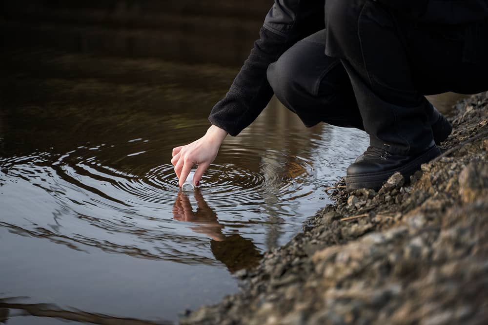 Environmental engineer collecting water samples at mining operation using Sublime Environmental treatment systems for regulatory compliance