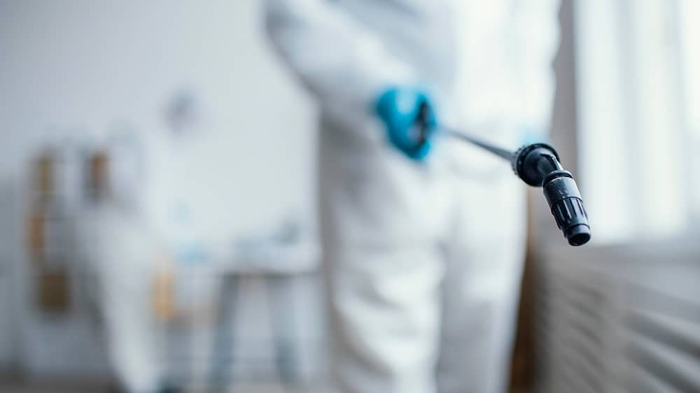 Personnel disinfecting pharmaceutical manufacturing area using Sublime Environmental chemical-free ozone treatment system for regulatory compliance