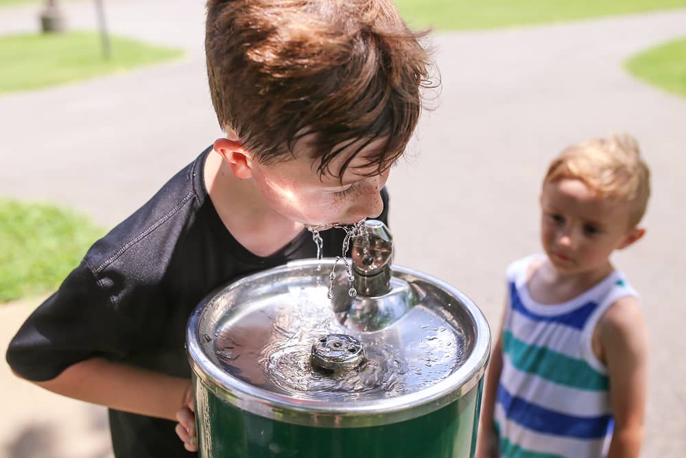 Children enjoying clean water at public park with water treatment systems by Sublime Environmental